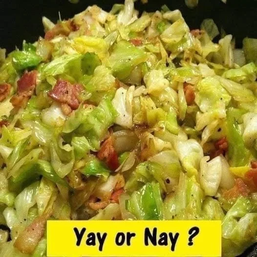 Plate of fried cabbage with bacon, onion, and garlic garnish