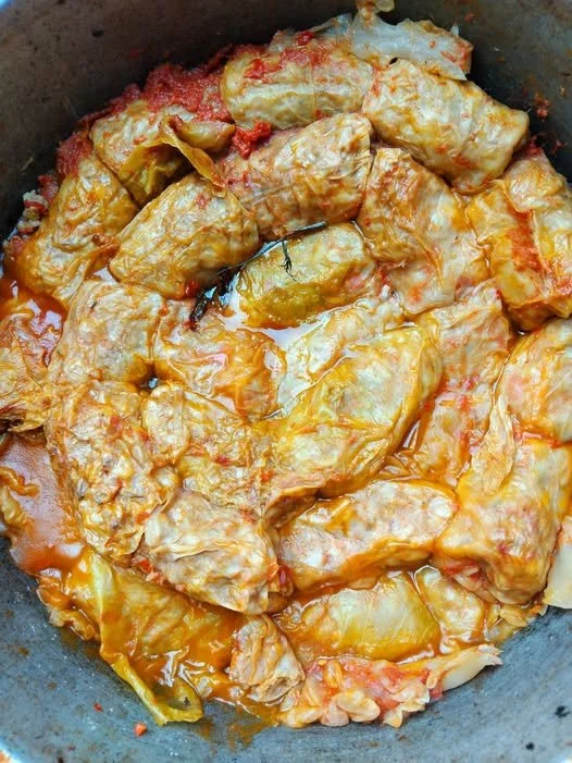 Sarmale tradiționale preparate cu carne și orez, servite cu smântână.
